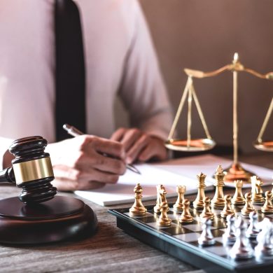 Legal law, advice and justice concept, Professional male lawyers working on courtroom sitting at the table and signing papers with gavel and Scales of justice.